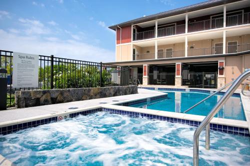 a swimming pool in front of a building at Holiday Inn Express & Suites Kailua-Kona by IHG in Kailua-Kona