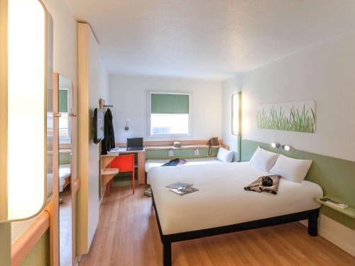 a hotel room with a bed and a desk at Ibis Budget Valencia Aeropuerto in Manises