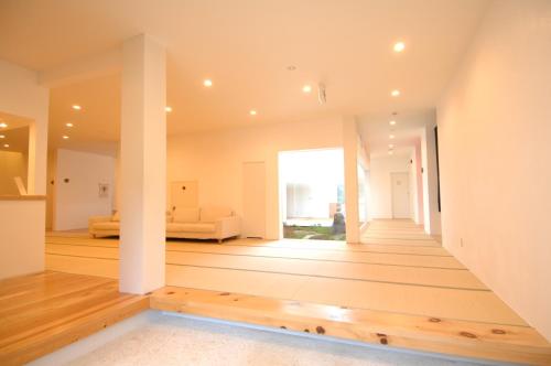 a living room with white walls and wood floors at Zen no Yu in Kawazu