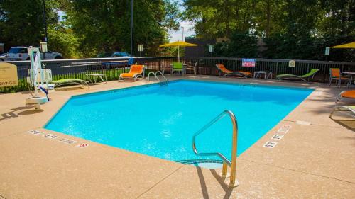 a large blue swimming pool with chairs and umbrellas at Holiday Inn Express Hotel & Suites Kinston by IHG in Kinston