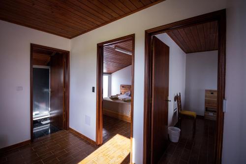 a hallway with a room with a bed and a mirror at Ponta Delgada Guest House 2 in Arrifes