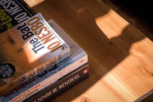 two books sitting on top of a wooden table at Ponta Delgada Guest House 2 in Arrifes