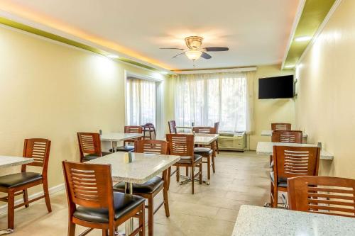 a dining room with tables and chairs and a tv at Hermitage Hotel Richmond Virginia in Richmond