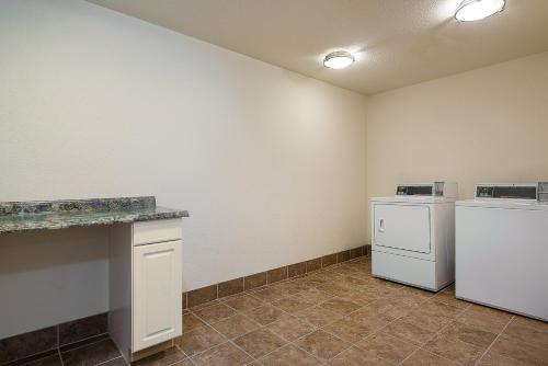 a laundry room with two refrigerators and a counter at Holiday Inn Express and Suites Lafayette East by IHG in Lafayette