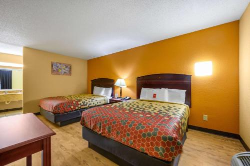 ein Hotelzimmer mit 2 Betten und einem Tisch in der Unterkunft Econo Lodge in Decatur