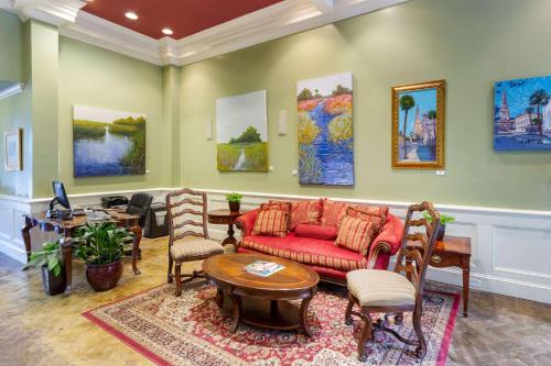 a living room with a red couch and chairs at Church Street Inn, Ascend Hotel Collection in Charleston