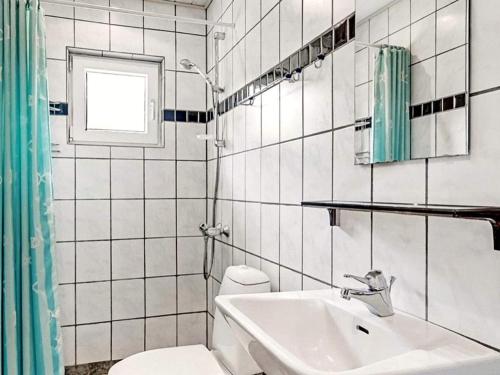 uma casa de banho com um lavatório, um WC e uma janela. em Holiday home Oksbøl II em Oksbøl