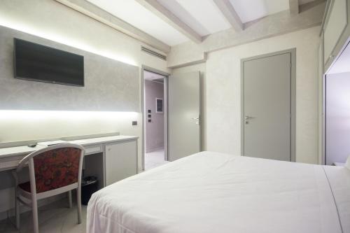 a bedroom with a bed and a desk and a tv at Best Western Modena District in Campogalliano