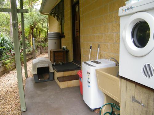 a washer and dryer sitting outside of a house at Mount Browne Cottage in Coffs Harbour