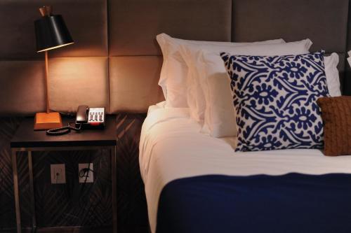 um quarto de hotel com uma cama e um telefone numa mesa em Figueiras Hotel & Eventos em São Miguel dʼOeste
