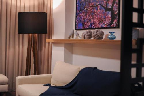 a living room with a white couch and a lamp at Figueiras Hotel & Eventos in São Miguel dʼOeste