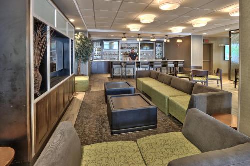 a waiting room with couches and a bar at Holiday Inn & Suites Albuquerque-North I-25 by IHG in Albuquerque