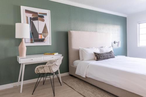 a bedroom with a bed and a table and a chair at Signature Inn Oakland in Oakland