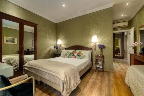 a bedroom with a large bed and a mirror at BQ House Trevi Luxury Rooms in Rome