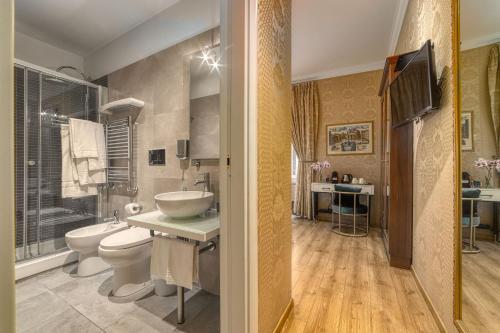 a bathroom with a sink and a toilet and a tub at BQ House Trevi Luxury Rooms in Rome