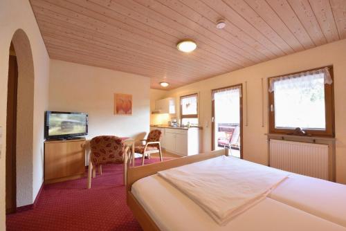 Habitación de hotel con cama y TV en Gästehaus Roseneck, en Todtmoos