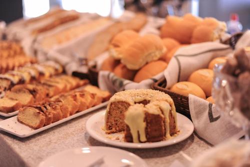 a table topped with different types of bread and pastries at Figueiras Hotel & Eventos in São Miguel dʼOeste