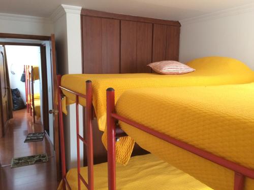 派帕的住宿－Casa Vacacional La Estación Paipa，配有黄床单的客房内的两张双层床