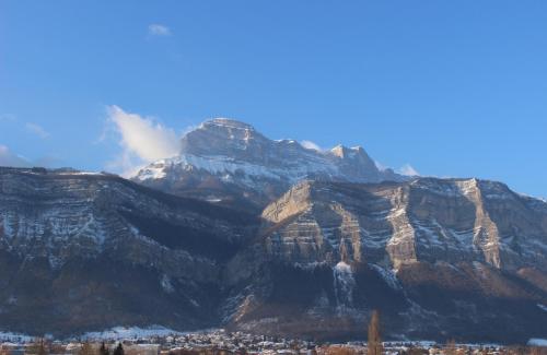 a mountain with a city in front of it at Ibis Styles Crolles Grenoble A41 in Crolles
