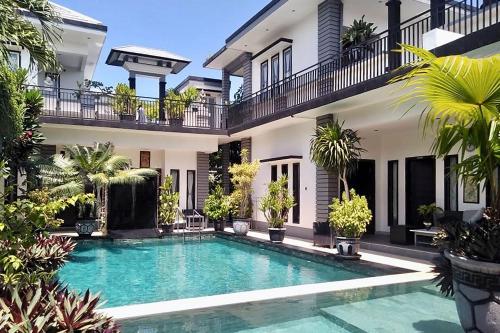 a swimming pool in front of a house at Villa Rumah Putih Abu Abu in Senggigi 