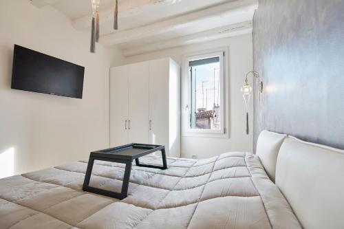 Un dormitorio con una cama con una mesa encima. en Classy Venice, en Venecia