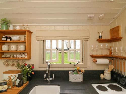 cocina con fregadero y ventana en Gibson's Hut en Preston Candover