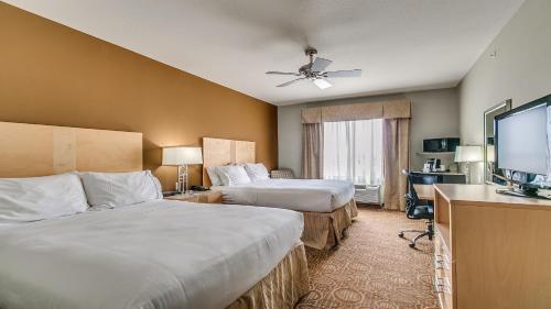 a hotel room with two beds and a flat screen tv at Holiday Inn Express & Suites Lubbock Southwest – Wolfforth by IHG in Lubbock
