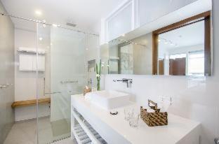 ein weißes Badezimmer mit einem Waschbecken und einem Spiegel in der Unterkunft Coast Boracay in Boracay