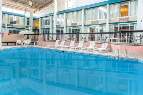 a swimming pool in a building with chairs and tables at Quality Inn and Conference Center in Springfield