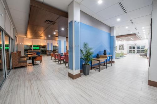 an empty lobby of an office with tables and chairs at Holiday Inn Express & Suites - Houston Westchase - Westheimer by IHG in Houston