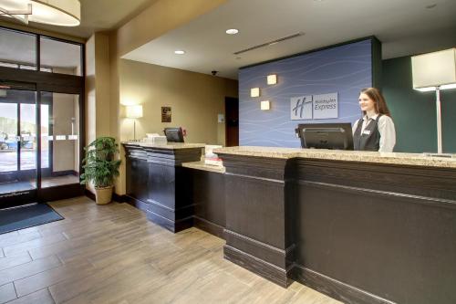 a woman standing at a counter in a hotel lobby at Holiday Inn Express Natchez South West by IHG in Natchez
