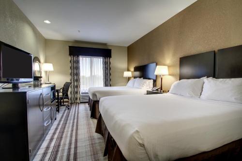 a hotel room with two beds and a flat screen tv at Holiday Inn Express Natchez South West by IHG in Natchez