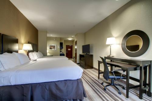 a hotel room with a large bed and a desk at Holiday Inn Express Natchez South West by IHG in Natchez