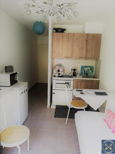 Il comprend une petite cuisine équipée d'une cuisinière, d'une table et de chaises. dans l'établissement NICE VIEW Jolie Studio avec Jardin, à Nice
