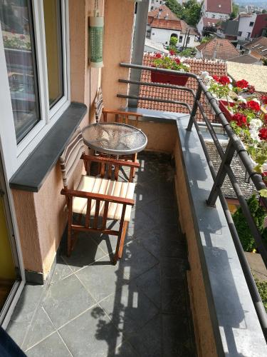 a patio with a table and chairs on a balcony at Helena Apartment in Novi Sad