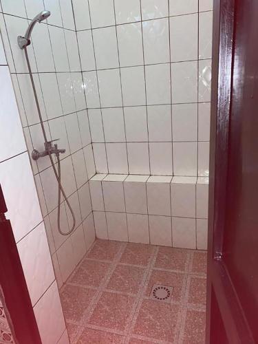 a bathroom with a shower with a tile floor at Palm garden Resort in Gisenyi