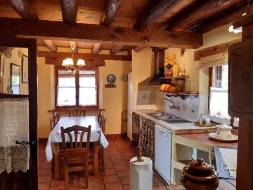 a kitchen with a table and a stove and a table and chairs at La cerca de la Mata, decerca in Arcones