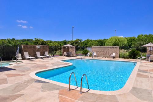 une grande piscine entourée de chaises dans l'établissement Holiday Inn Express & Suites Selma, an IHG Hotel, à Selma