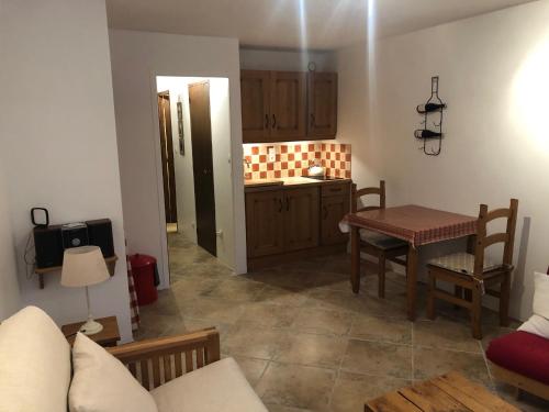 un salon avec une table et une cuisine dans l'établissement La Plagne/Champagny Studio, à Champagny-en-Vanoise