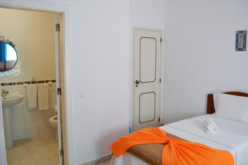 una camera da letto con un letto con un arco arancione sopra di Alvor House Lagoon ad Alvor