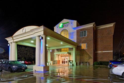 a hotel building with a car parked in a parking lot at Holiday Inn Express & Suites San Antonio South by IHG in San Antonio