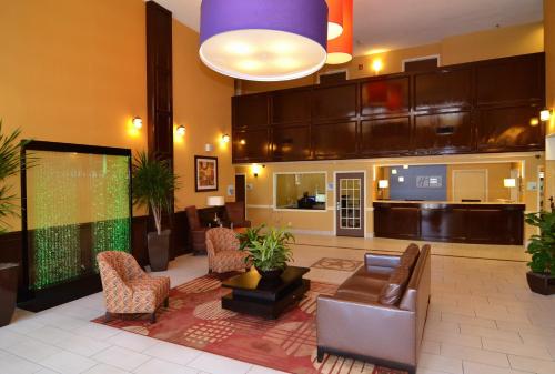 a lobby with a waiting area with leather chairs and a video game at Holiday Inn Express Hotel & Suites San Antonio-Airport North, an IHG Hotel in San Antonio