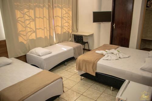 a hotel room with two beds and a fireplace at Bento palace hotel in Assis