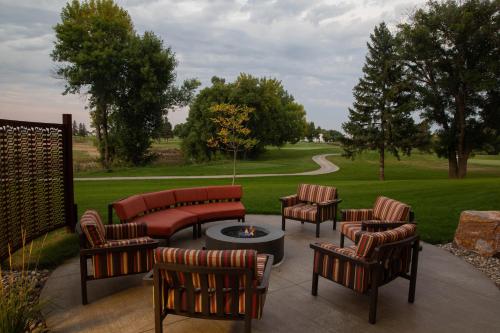 a patio with chairs and a table and a fire pit at Holiday Inn & Suites Sioux Falls - Airport by IHG in Sioux Falls