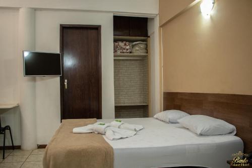 a bedroom with a bed with towels on it at Bento palace hotel in Assis