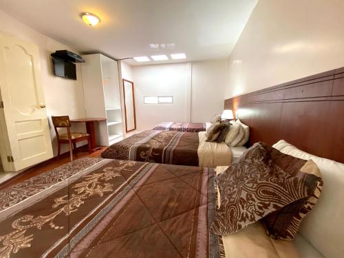 a hotel room with two beds and a table at Rio Hotel in Riobamba