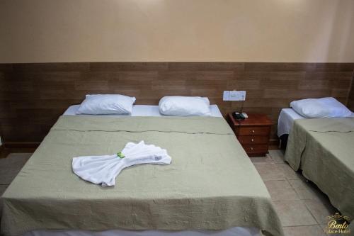 a bedroom with two beds with white towels on them at Bento palace hotel in Assis