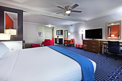 a hotel room with a bed and a flat screen tv at Holiday Inn Express & Suites Houston East by IHG in Houston