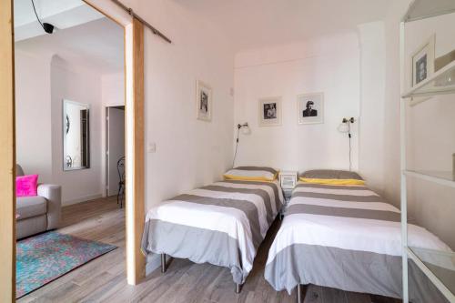deux lits dans une chambre avec un miroir dans l'établissement Romantic and new apartment in the famous Rue Meynadier in the supercentre of Cannes, à Cannes