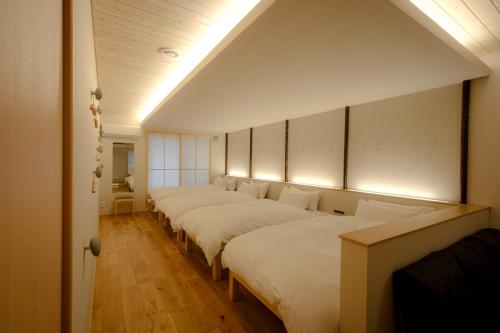 a row of beds lined up in a room at so, KANAZAWA in Kanazawa